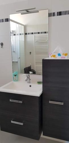 une salle de bain avec un lavabo et un miroir dans l'établissement Le MINOU, à Roquebrune-Cap-Martin