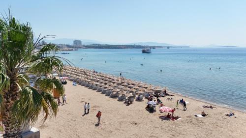 a group of people on a beach near the water at Sürer Apart Altınkum in Didim