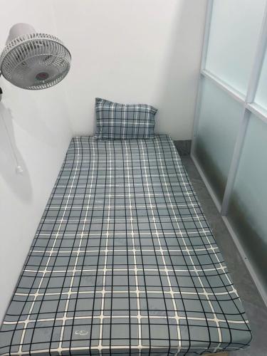 a small bed in a room with a fan at Bằng Lăng Tím in Ấp Bình Tú