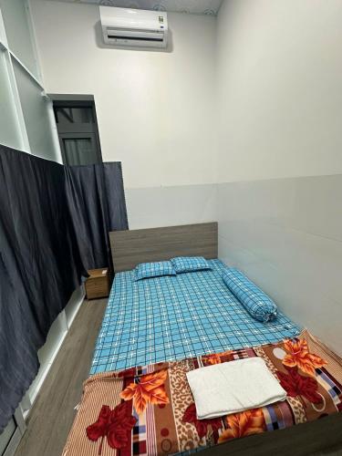 a bedroom with a bed with a quilt on it at Bằng Lăng Tím in Ấp Bình Tú