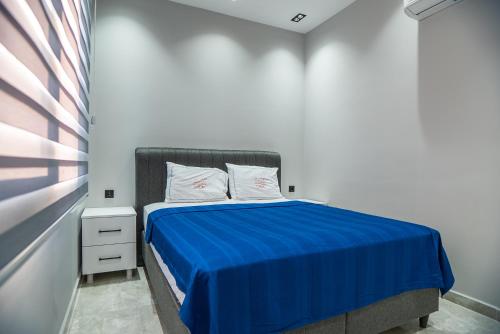a bedroom with a bed with a blue blanket at Sürer Apart Altınkum in Didim