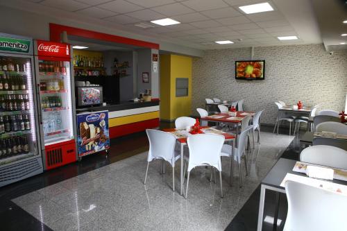 a fast food restaurant with tables and white chairs at Hotel Iris in Plovdiv