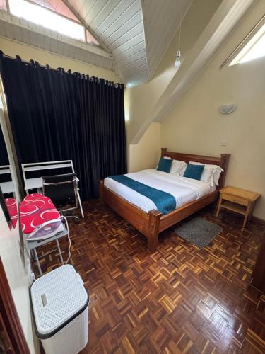 a bedroom with a bed and a wooden floor at La Pace One Bedroom Home, Rhapta Road Westlands Nairobi in Nairobi