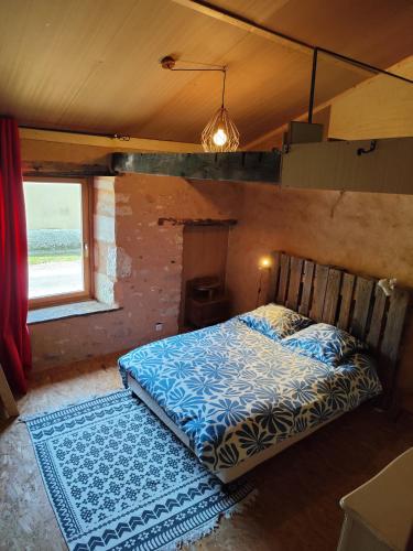 - une chambre avec un lit, une fenêtre et un tapis dans l'établissement Maison d'artiste atypique en bordure de forêt, à Cellefrouin