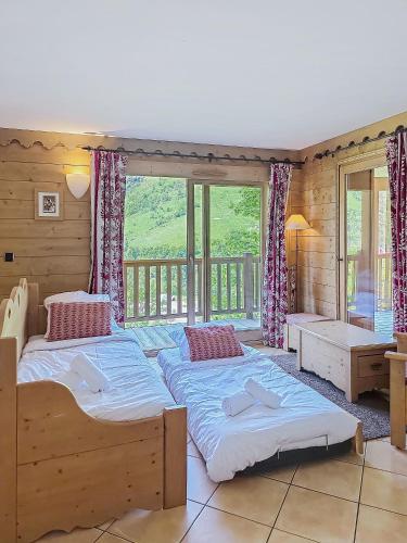 une chambre avec deux lits et une grande fenêtre dans l'établissement La Croix des Vallées - Proche des pistes des Ménuires, aux Menuires