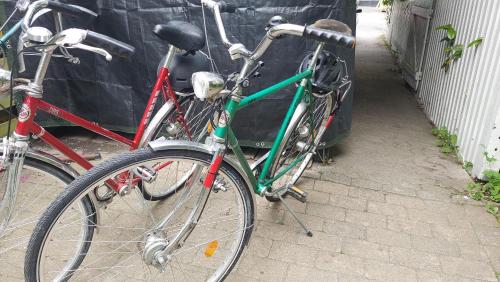 two bikes are parked next to a car at Villa Rosa, dobblebed, own kitchen, own bath and own entrance in Copenhagen