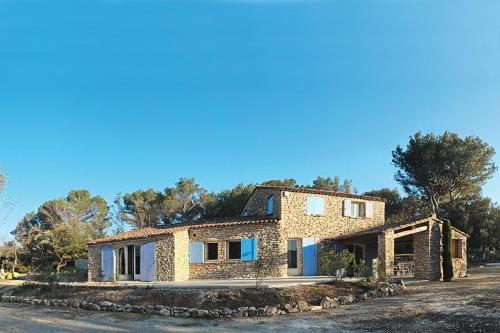 une maison en pierre sur le côté d'une route dans l'établissement Mas provençal - Beautiful Provencal farmhouse, heated pool, à Murs