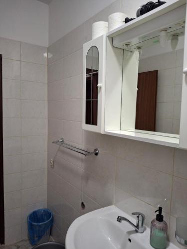 a white bathroom with a sink and a mirror at Villa Luketa in Podstrana
