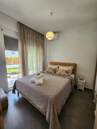 a bedroom with a bed and a large window at Mar Greco in Skala Rachoniou