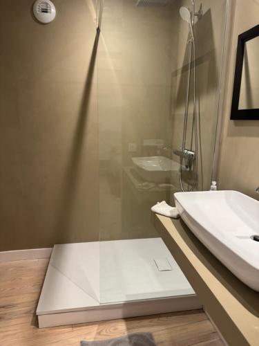 une salle de bain avec une douche en verre et un lavabo dans l'établissement Les remparts de Guerande, à Guérande
