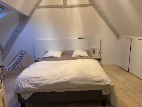 une chambre avec un grand lit dans un grenier dans l'établissement Les remparts de Guerande, à Guérande