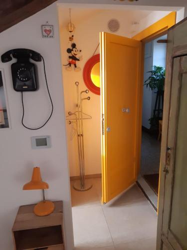 a room with a yellow door and a phone on the wall at La Mansarda delle Mongolfiere in Turin