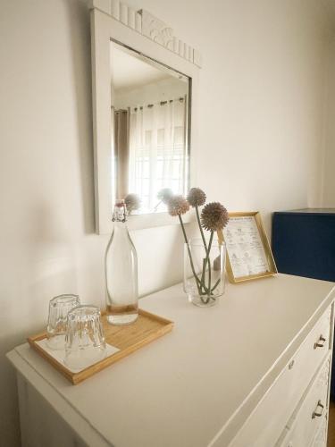 a white counter with two vases and a mirror at Offshore Rustic House in Peniche