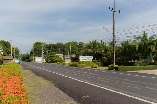 an empty street with flowers on the side of a road at Baan Faa Talaychan Resort in Chao Lao Beach