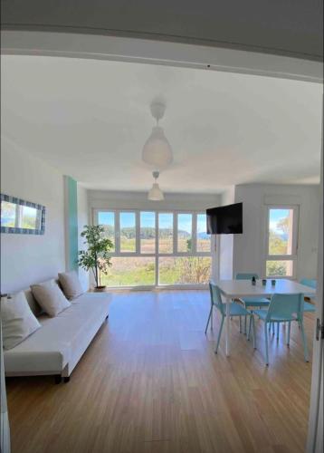 a living room with a white couch and a table at Tranquilo apartamento cerca de la playa in Carballal