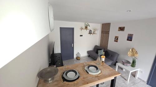 un salon avec une table en bois et un canapé dans l'établissement Charmant Appartement dans village typique du Sud, à Lespignan