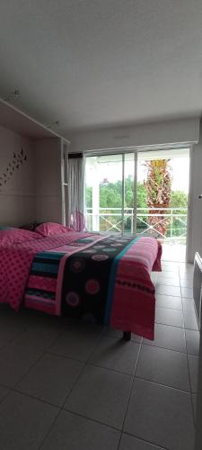 une chambre avec un lit et une grande fenêtre dans l'établissement Location d Armelle - Moliets, à Moliets-et-Maa