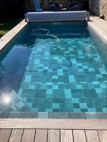 - une piscine revêtue de carrelage bleu dans l'établissement Propriété de cœur de ville avec piscine et jardin partagés, à Saint-Pierre-dʼOléron