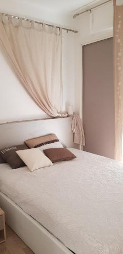 une chambre avec un grand lit blanc avec des rideaux dans l'établissement Le MINOU, à Roquebrune-Cap-Martin
