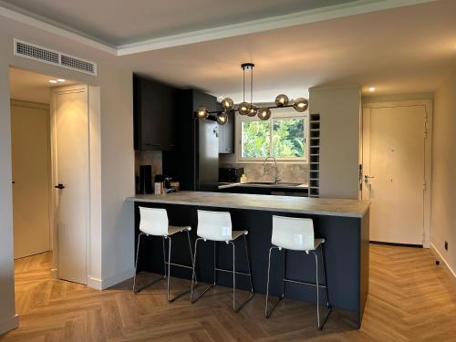 une cuisine avec un îlot bleu et des tabourets de bar dans l'établissement Cannes Centre Cosy Appartement proche des plages, à Cannes