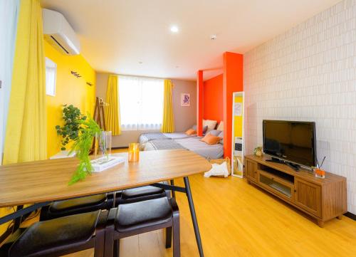 a living room with a table and a television at Rambler 202 in Sapporo