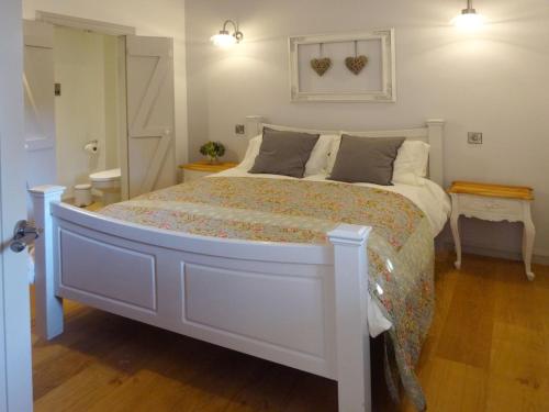 a bedroom with a large white bed in a room at Yondhill Barn in Okehampton