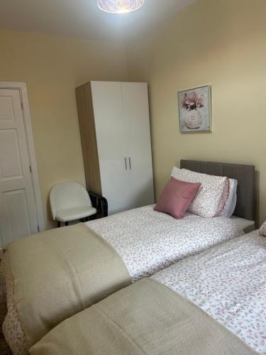 a bedroom with two beds and a white cabinet at Árasann Clochán in Cloghan