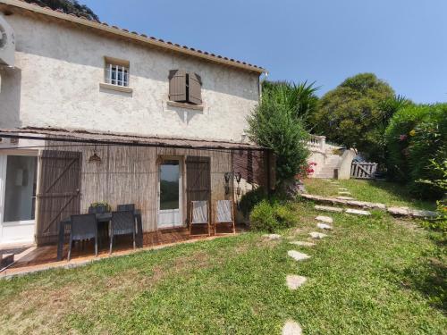 - une vue extérieure sur une maison avec une cour dans l'établissement Chez LINAT - Studio en rez de jardin au calme avec vue mer, à Vallauris