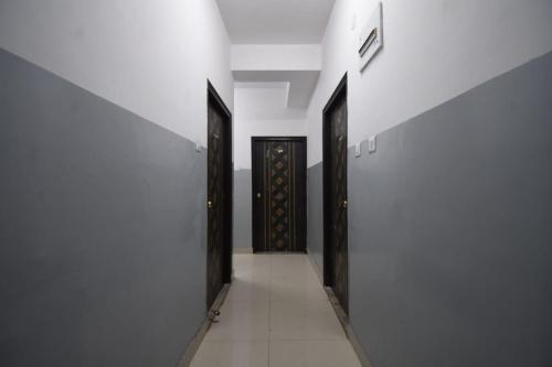 a hallway with two doors in a white wall at OYO 82026 BANGUR INN in Nager Bazaar
