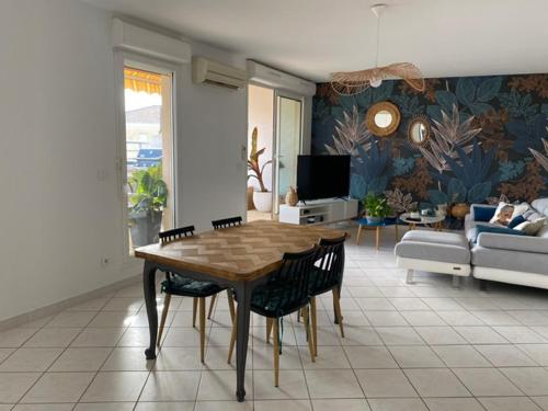 un salon avec une table et des chaises en bois dans l'établissement Adélice, à Hyères