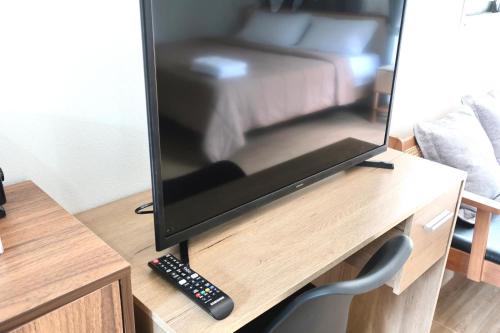 Un televisor sobre una mesa de madera con un control remoto. en First Light beach bungalow 1, en Ko Pha Ngan