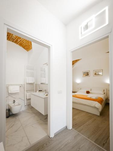 a white bedroom with a bed and a bathroom at Belvedere 237A Lakeview Luxury Apartment in Ghiffa