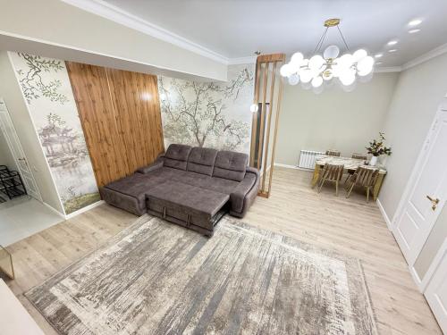 a living room with a couch and a table at Citywide apartment BayTash Tower near GUM and TSUM in Bishkek