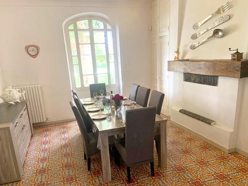 une salle à manger avec une table, des chaises et une cheminée dans l'établissement Mas Bruneau, à Noves