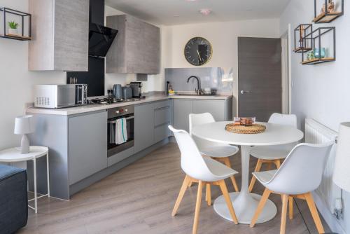 a kitchen with a white table and white chairs at No Seven Harbour Side in Poole