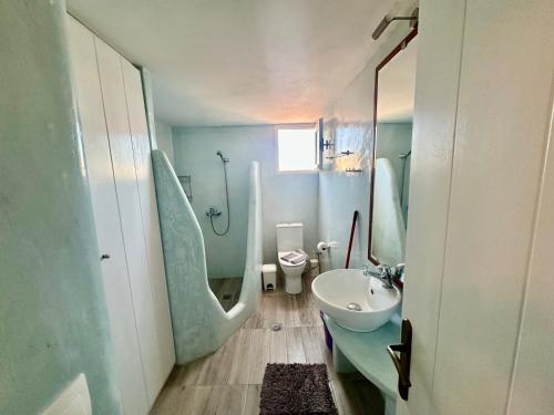 a bathroom with a sink and a shower and a toilet at Siesta Villas Cycladic Elegance with Castle View in Livadi Astypalaias