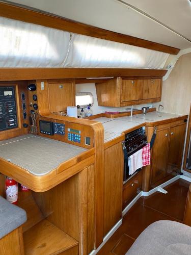 une petite cuisine avec des placards en bois et une cuisinière dans l'établissement Voilier 36 pieds à Sète au Môle Saint Louis face au Mont Saint Clair, à Sète