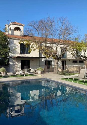 une piscine devant une maison dans l'établissement A l'ombre des pins, à Courthézon