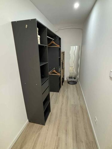 une pièce vide avec une grande étagère noire dans l'établissement Bel appartement à Riez, à Riez