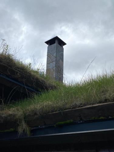 a grassy roof with a chimney on top of it at Bjørnebuhytten, Geilo, 13 sengeplasser med privat Jacuzzi og el-bil-lading in Geilo