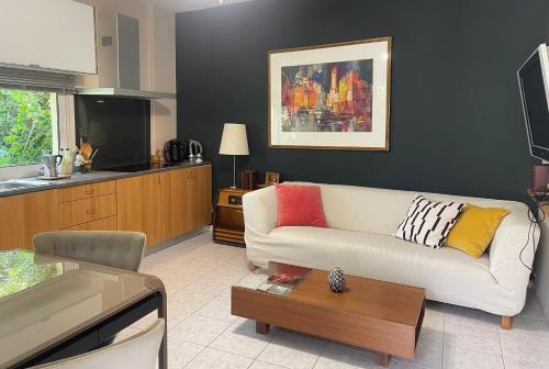 a living room with a white couch and a kitchen at the garden house in Dhaskalión