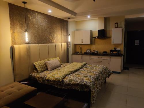 a bedroom with a bed and a couch in a kitchen at Studio Murree facing apartment In Bahria Enclave in Islamabad