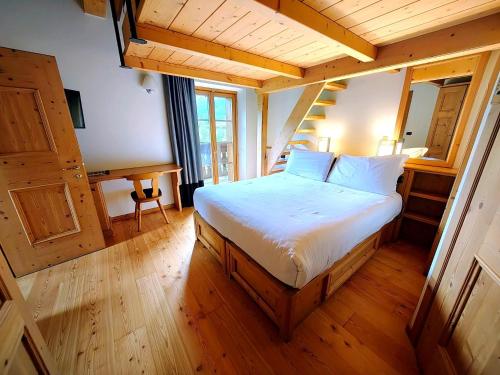 a bedroom with a bed in a room with wooden floors at Alpi & Golf Hotel in Bormio