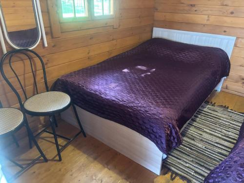 a small bedroom with a bed and two chairs at Ranna majake, Lake cottage , Peipsi Talu in Rootsiküla