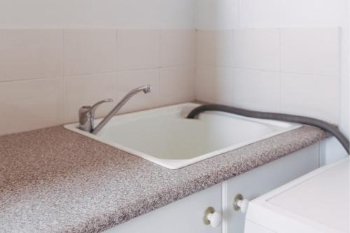 a bathroom sink with two faucets on a counter at Coastal getaway, tropical palms in Dee Why in Deewhy