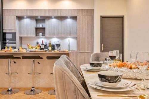 - une cuisine avec une table, des chaises et un comptoir dans l'établissement Elegant appartement 3 chambres, 3 salles de bain- Double séjour- Paris 16e- Calme et standing, à Paris