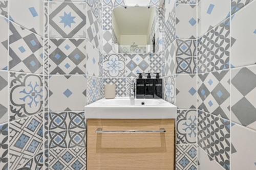 une salle de bain avec un lavabo et un miroir dans l'établissement Elegant appartement 3 chambres, 3 salles de bain- Double séjour- Paris 16e- Calme et standing, à Paris