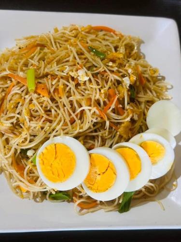 a plate of noodles with eggs on it at Sahan Tourist House in Polonnaruwa