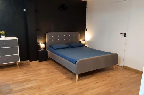 une chambre avec un lit avec des draps bleus et une commode dans l'établissement Stay zen Studio, à Marquay