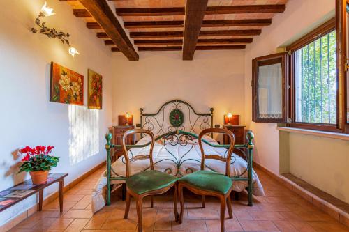 a bedroom with a bed and chairs in a room at La Casa di Gelsomino in Massa Martana